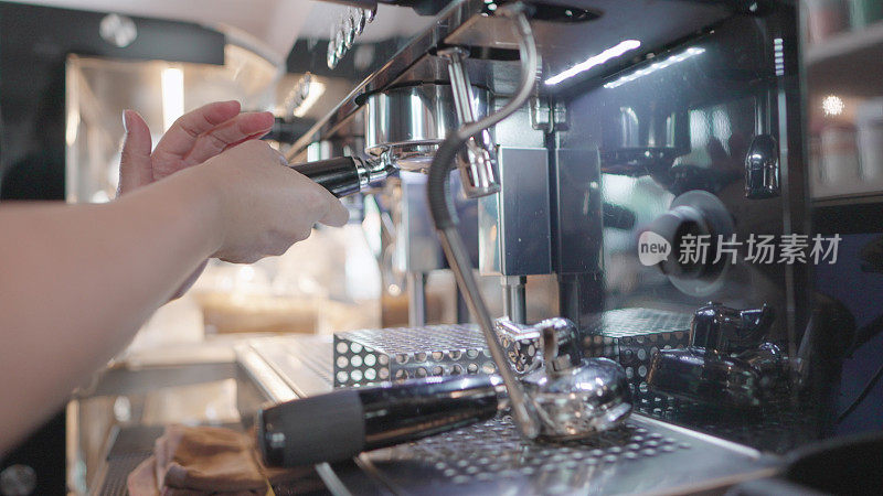 Professional barista making coffee for customers at the Café. Entrepreneur or employee standing behind the counter ready to serve customers or barista take the order in cafe. Young females business owner or manager working in coffee shop.